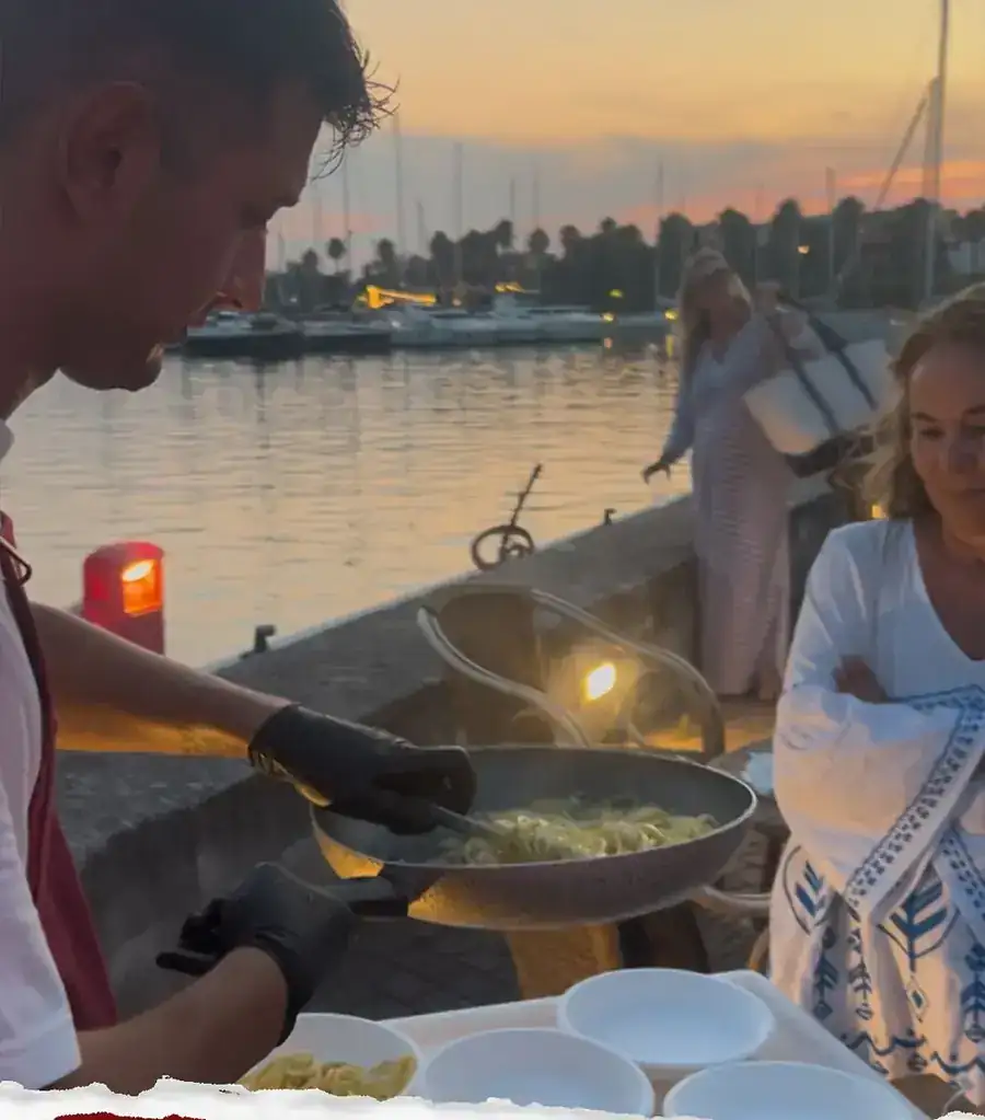 Roota chef cooking for guests at sunset by the harbour