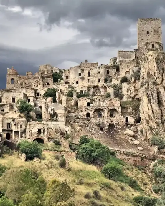 The abandoned ghost town of Craco on its rocky ridge, with its medieval tower under a stormy sky